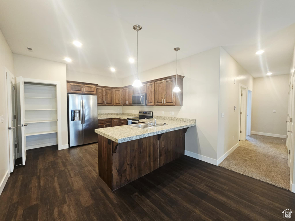 Kitchen with stainless steel appliances, a peninsula, light countertops, baseboards, and recessed lighting