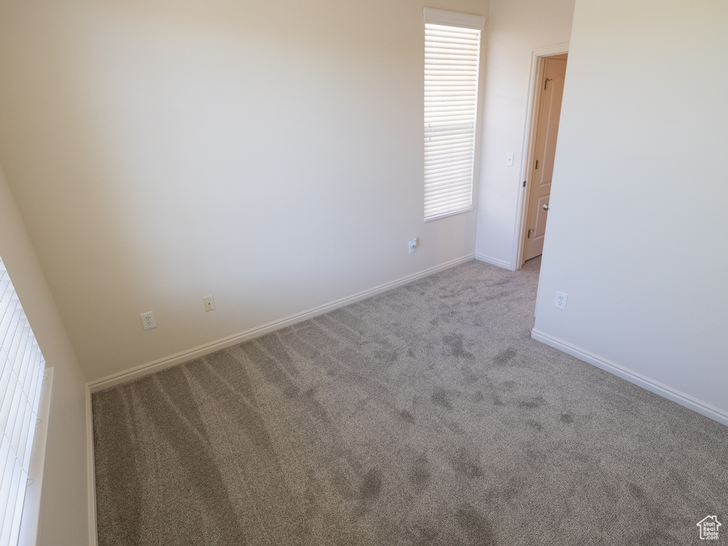 Empty room with carpet and baseboards