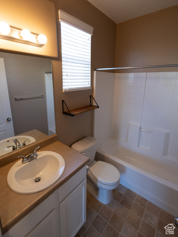 Bathroom featuring toilet, vanity, and shower / tub combination