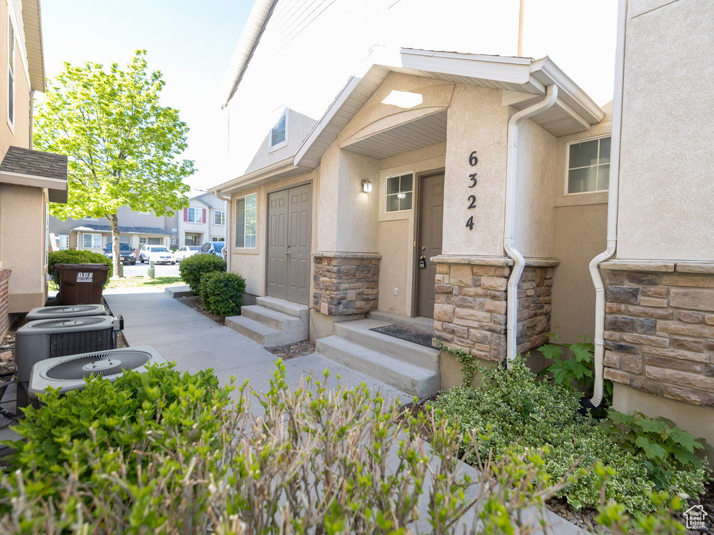 Doorway to property with stone siding and stucco siding