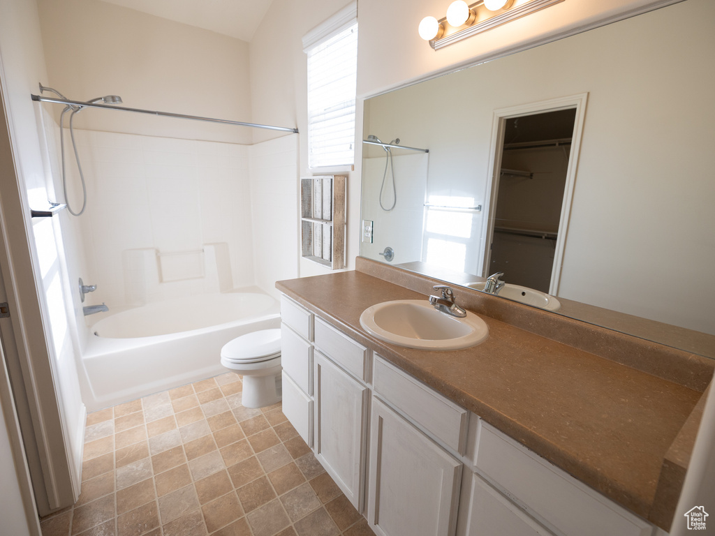 Bathroom with toilet, vanity, and washtub / shower combination