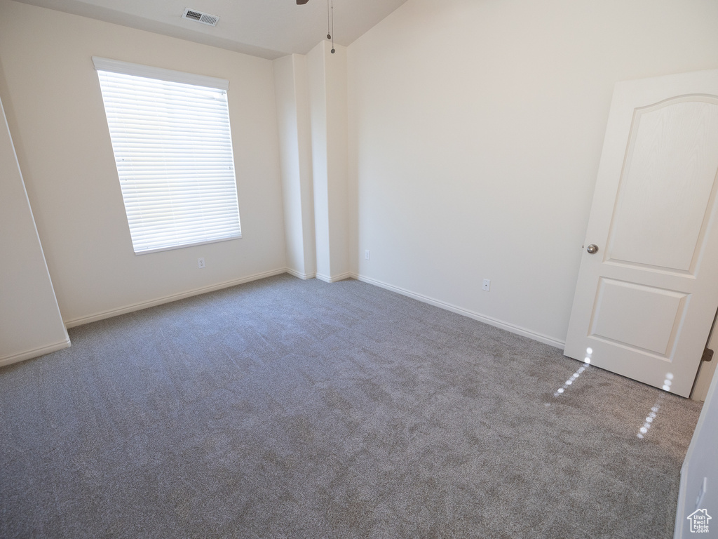 Spare room with carpet floors, ceiling fan, and baseboards