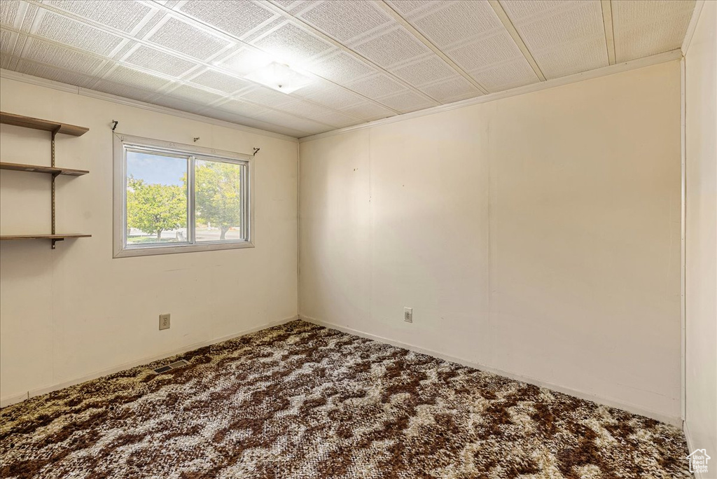 Carpeted spare room featuring baseboards