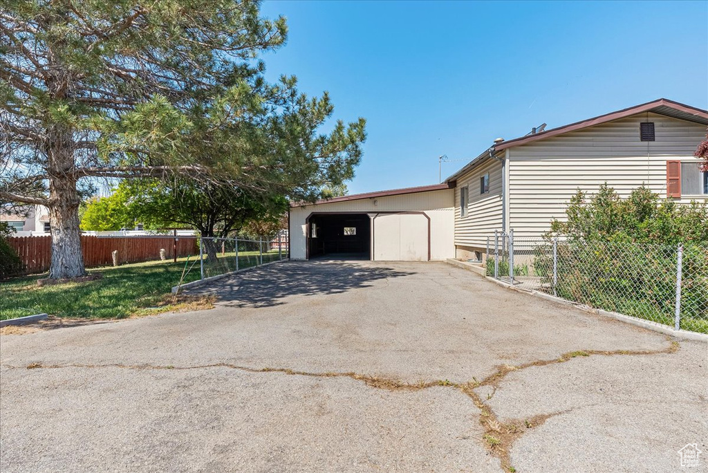 View of side of home with fence, a garage, and an outdoor structure