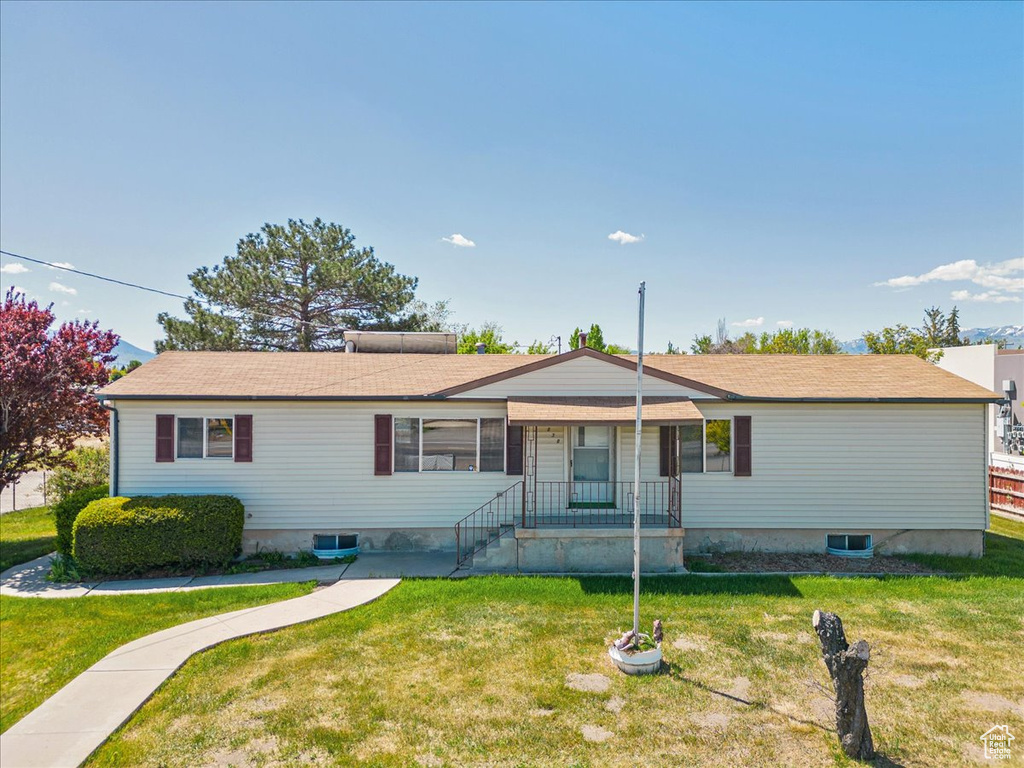 Single story home featuring a front lawn and covered porch