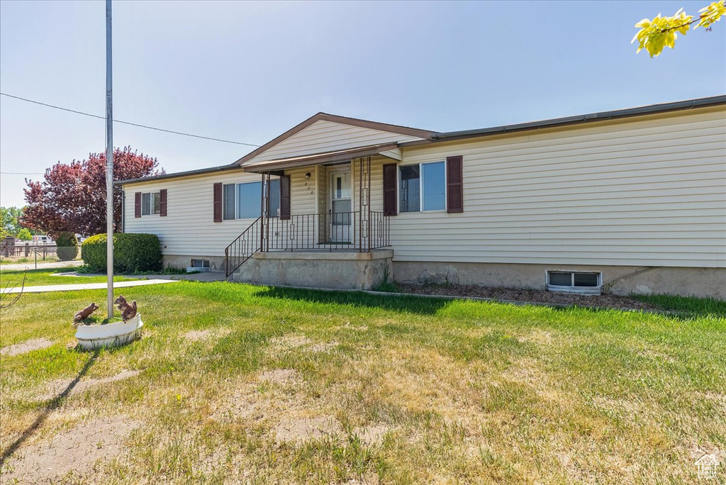 View of front of property with a front yard and covered porch