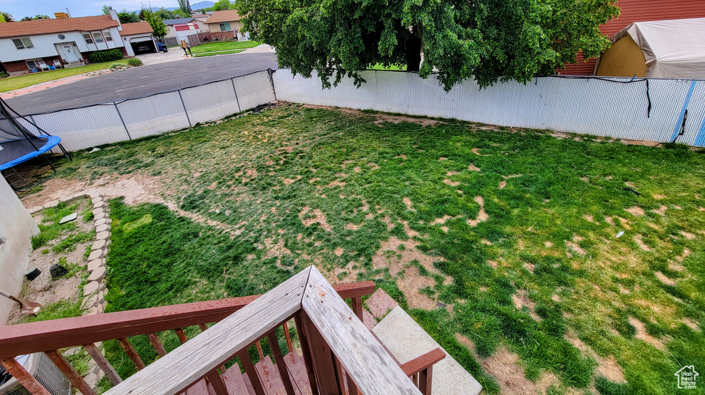 View of yard with a trampoline and a residential view