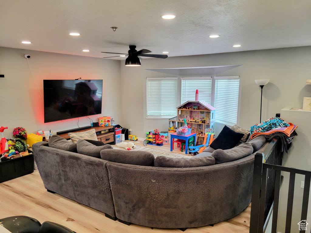 Living room with recessed lighting, light wood-style floors, and a ceiling fan