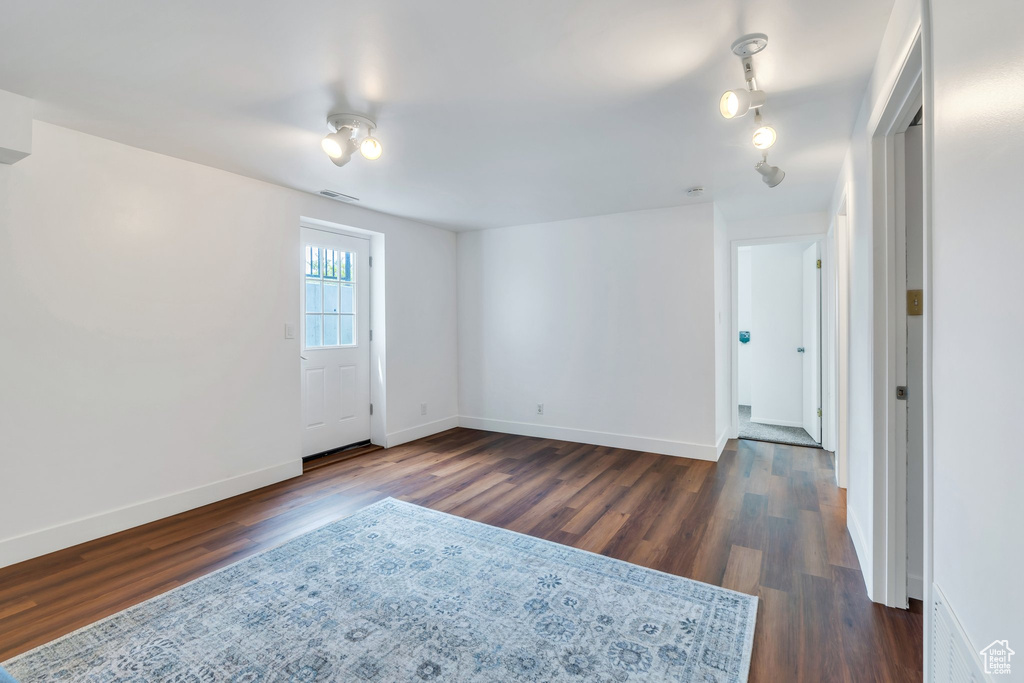 Empty room with dark wood-style floors and baseboards
