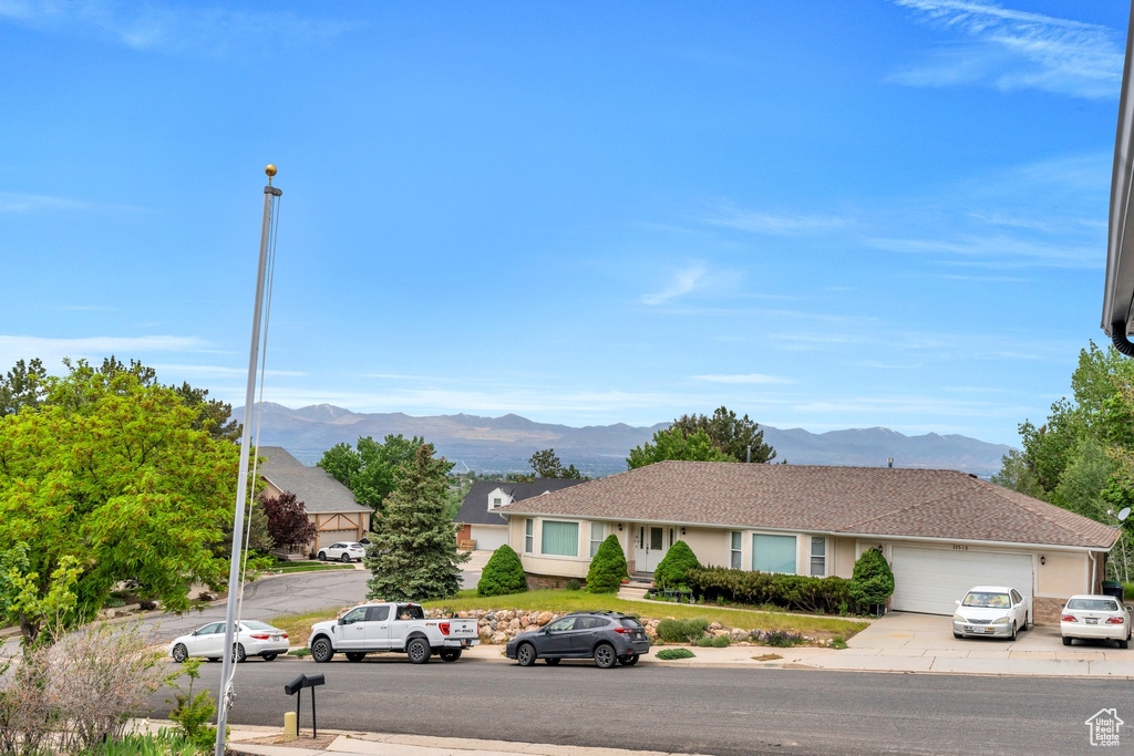 View of front of home featuring a mountain view, an attached garage, and concrete driveway