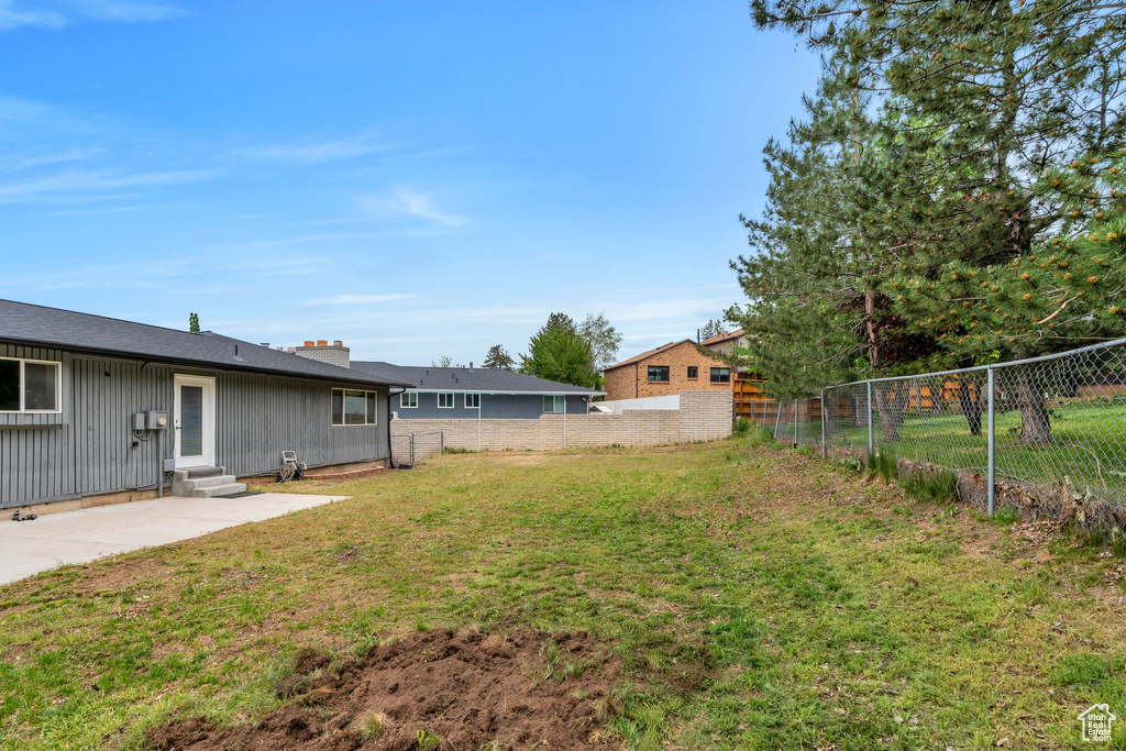 View of yard with entry steps and a patio