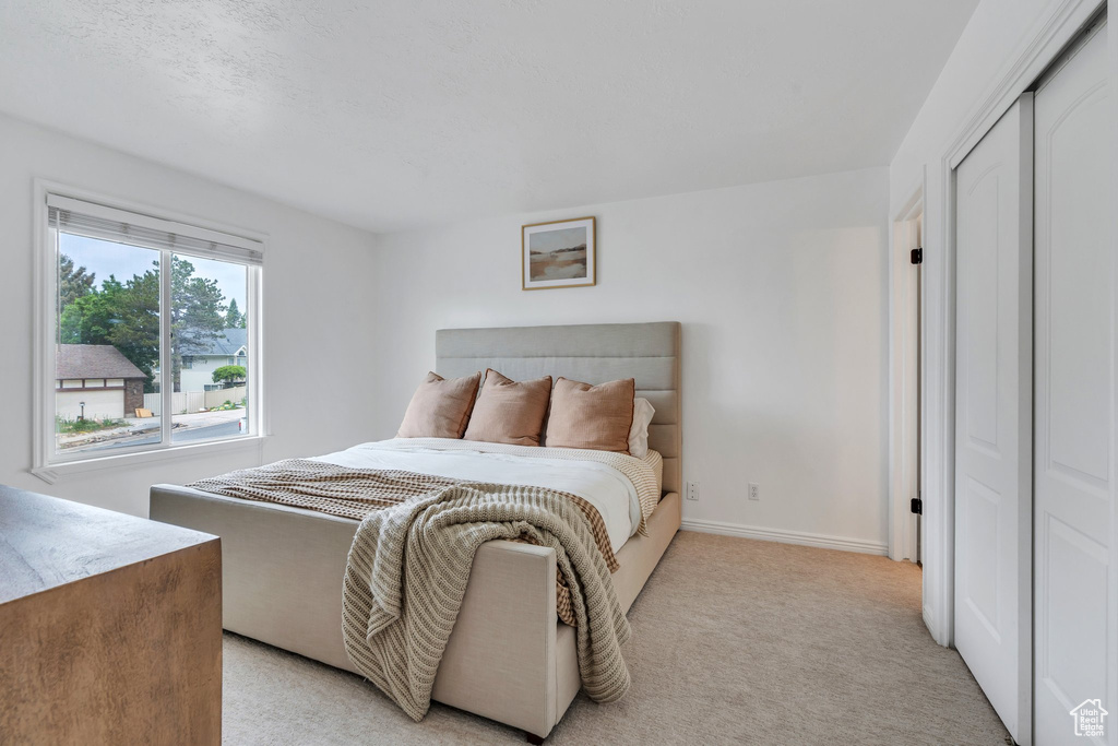 Bedroom with baseboards and light carpet