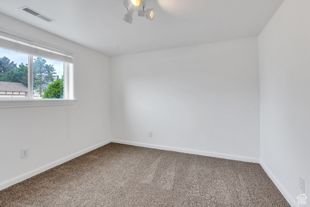 Carpeted spare room with baseboards