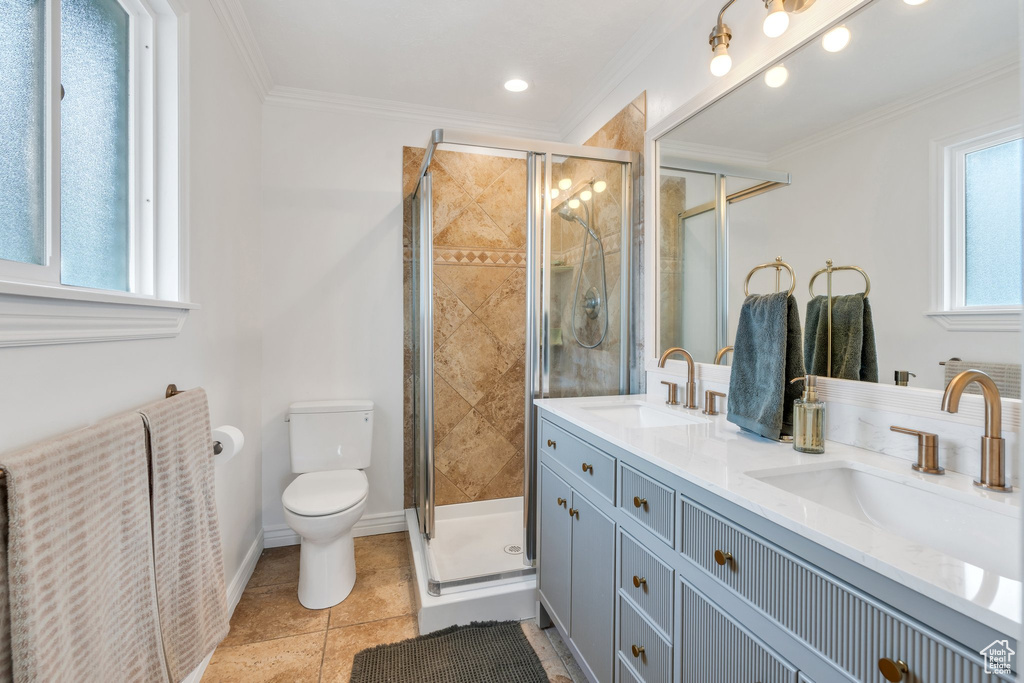 Bathroom with toilet, a stall shower, crown molding, double vanity, and tile patterned floors