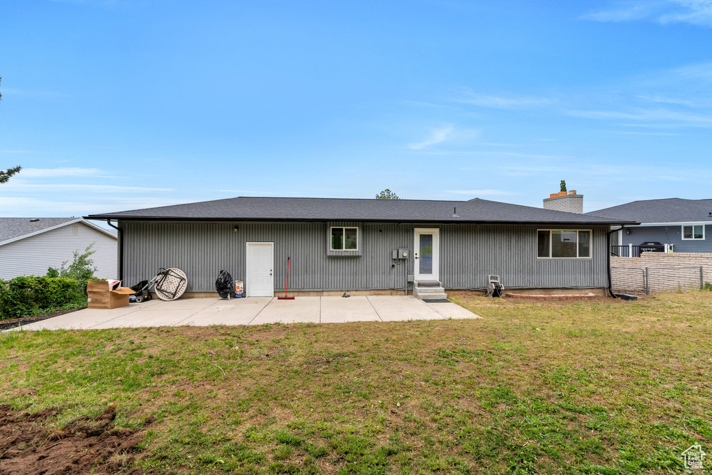 Back of property with a patio area, entry steps, and a chimney