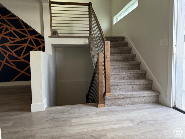 Stairs featuring wood finished floors