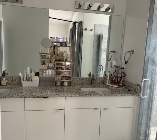 Full bath featuring a shower stall and vanity