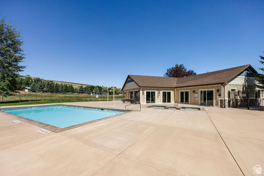 Community pool featuring fence, a patio, and a community hot tub