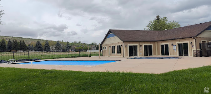 Community pool featuring a patio area and fence