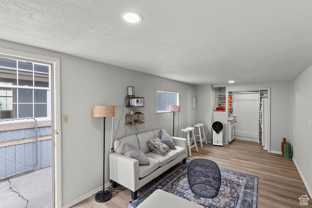 Living area featuring wood finished floors, baseboards, and a textured ceiling