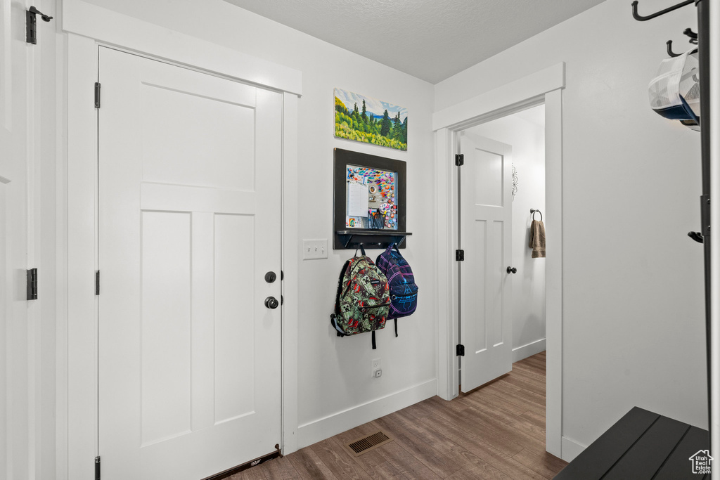 Foyer entrance with wood finished floors and baseboards