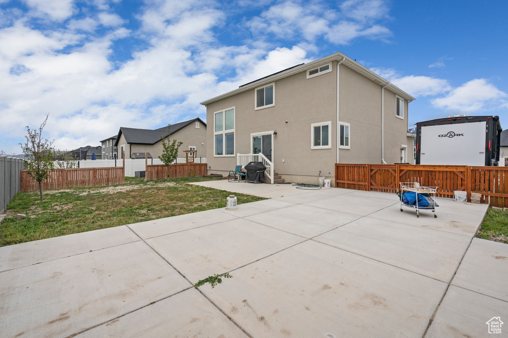 Back of house with a patio area, a fenced backyard, and stucco siding