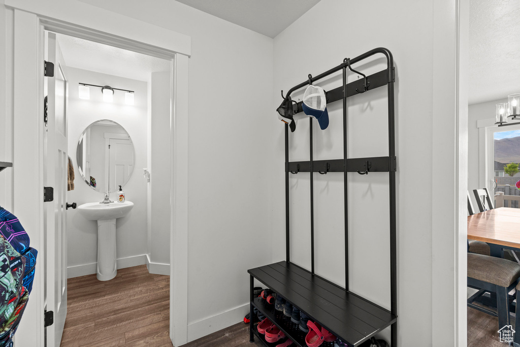 Bathroom with wood finished floors, baseboards, and a chandelier