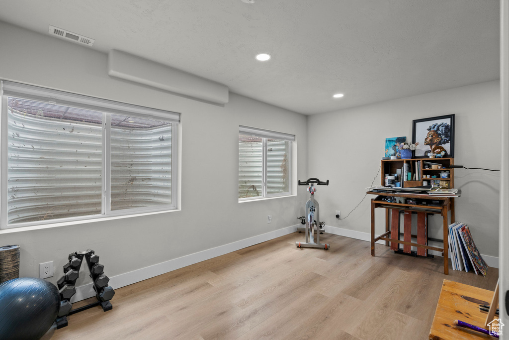 Workout area featuring wood finished floors, recessed lighting, and baseboards
