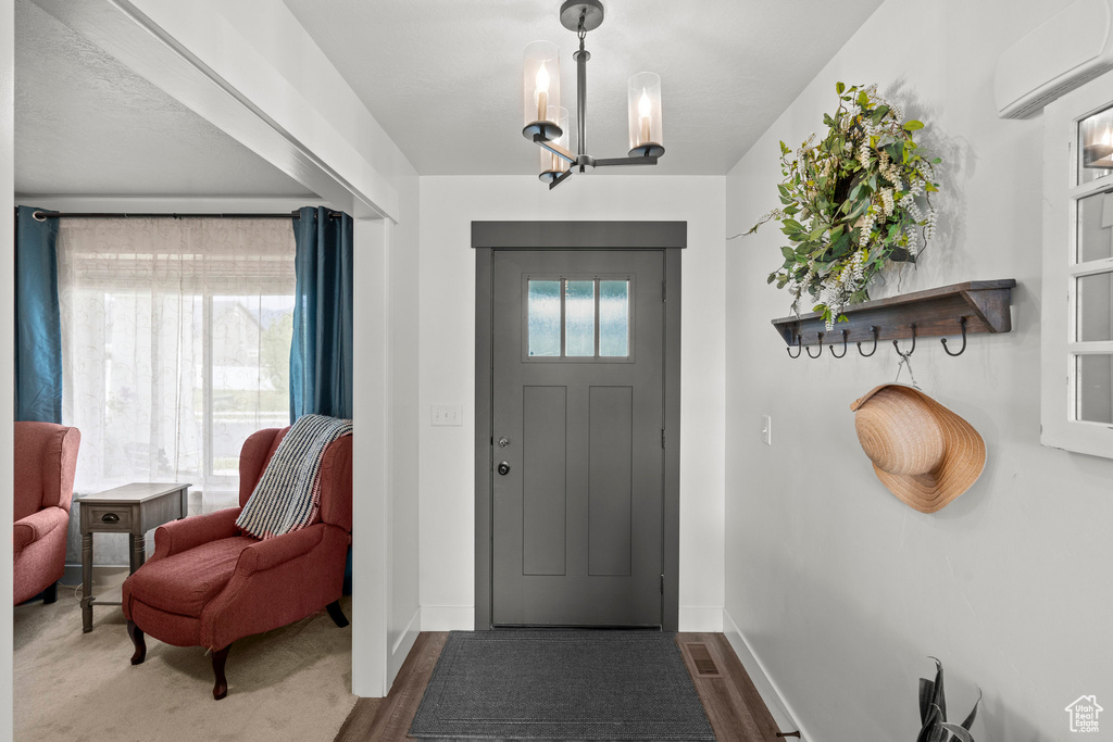 Entrance foyer featuring a chandelier and baseboards