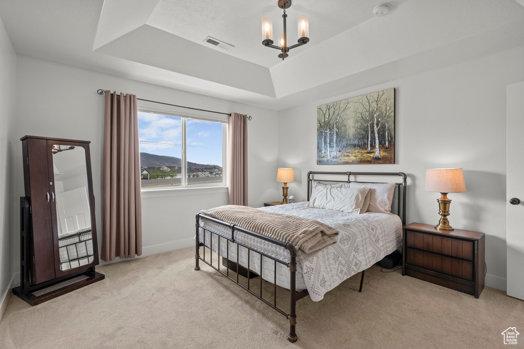 Bedroom with a raised ceiling, carpet, a chandelier, and baseboards