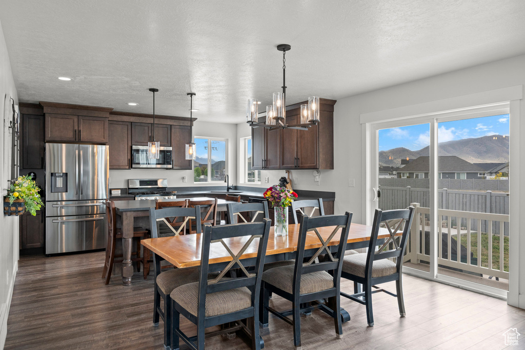 Dining area featuring dark wood-style flooring, recessed lighting, and a chandelier