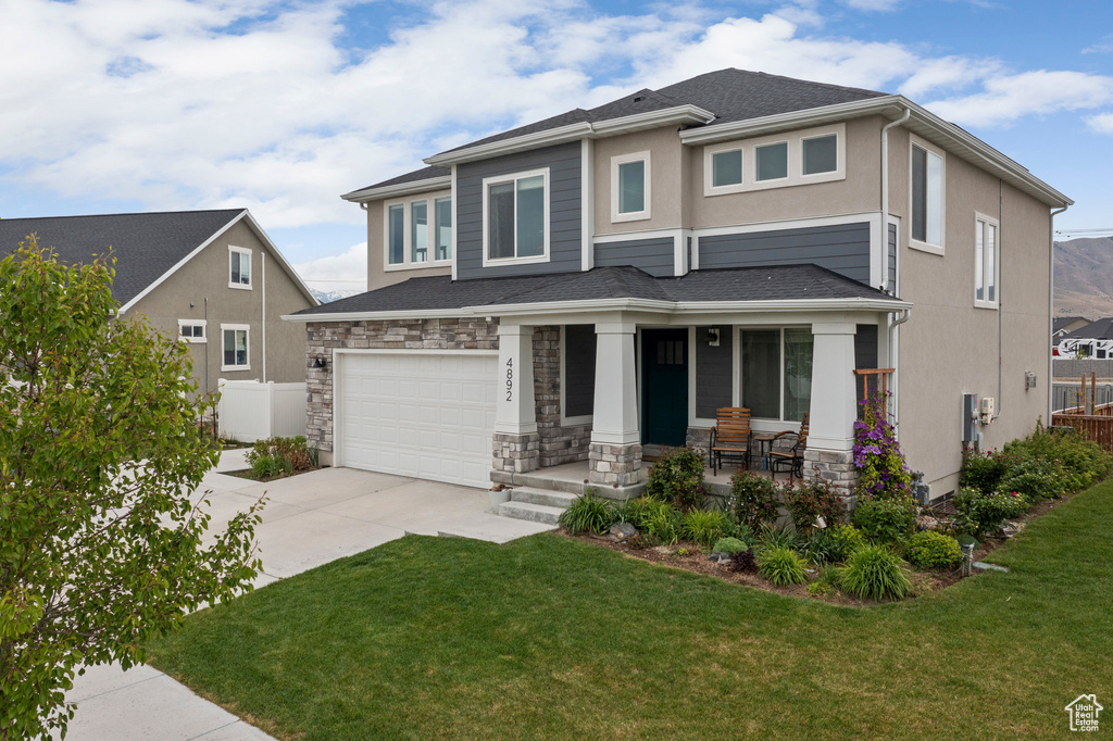 Prairie-style home with covered porch, concrete driveway, a garage, and stucco siding