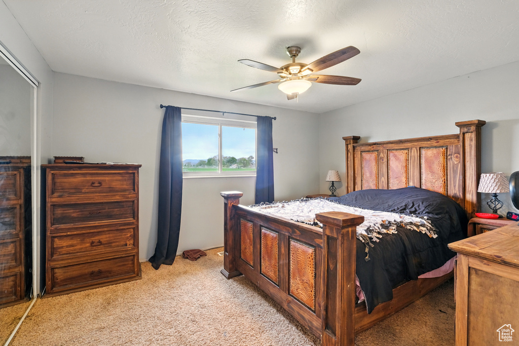 Bedroom with light colored carpet and ceiling fan