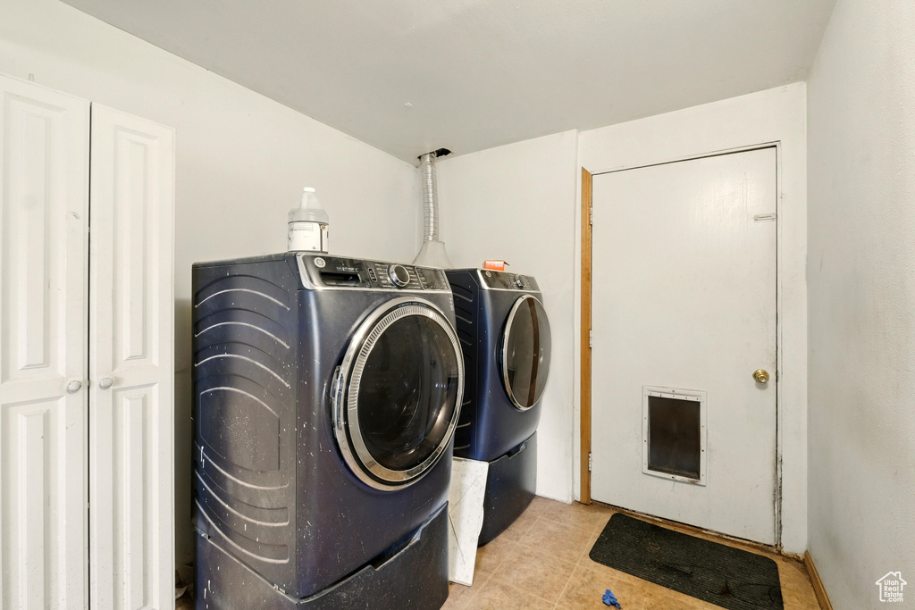 Washroom featuring independent washer and dryer and tile patterned flooring