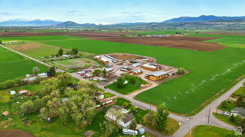 Aerial view of property and surrounding area featuring rural landscape, a mountainous background, and extensive farmland