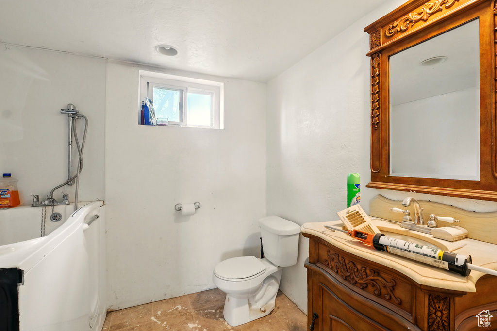 Bathroom with toilet, a bathtub, and vanity