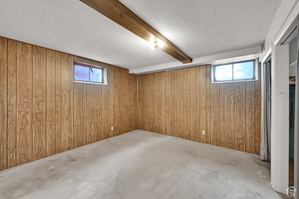 Basement featuring wood walls and a textured ceiling