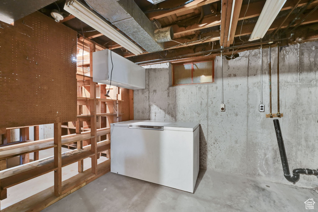 Unfinished below grade area with fridge