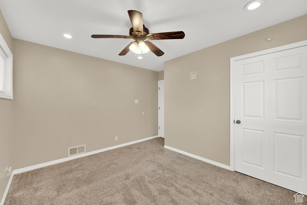 Carpeted empty room featuring a ceiling fan, baseboards, and recessed lighting