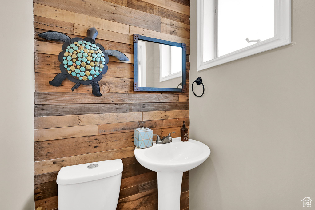 Half bath with wooden walls and toilet