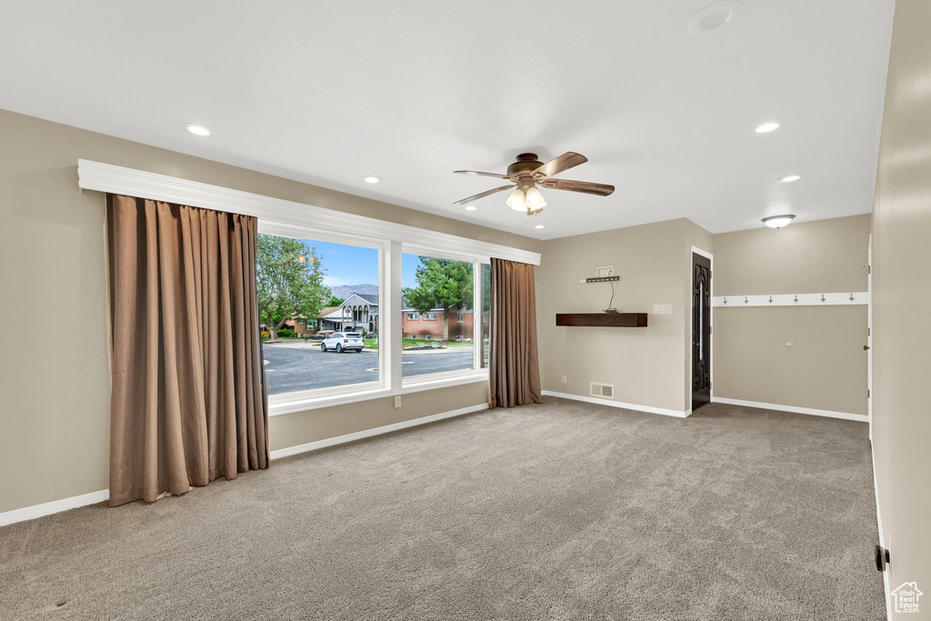 Unfurnished living room featuring a ceiling fan, carpet floors, baseboards, and recessed lighting