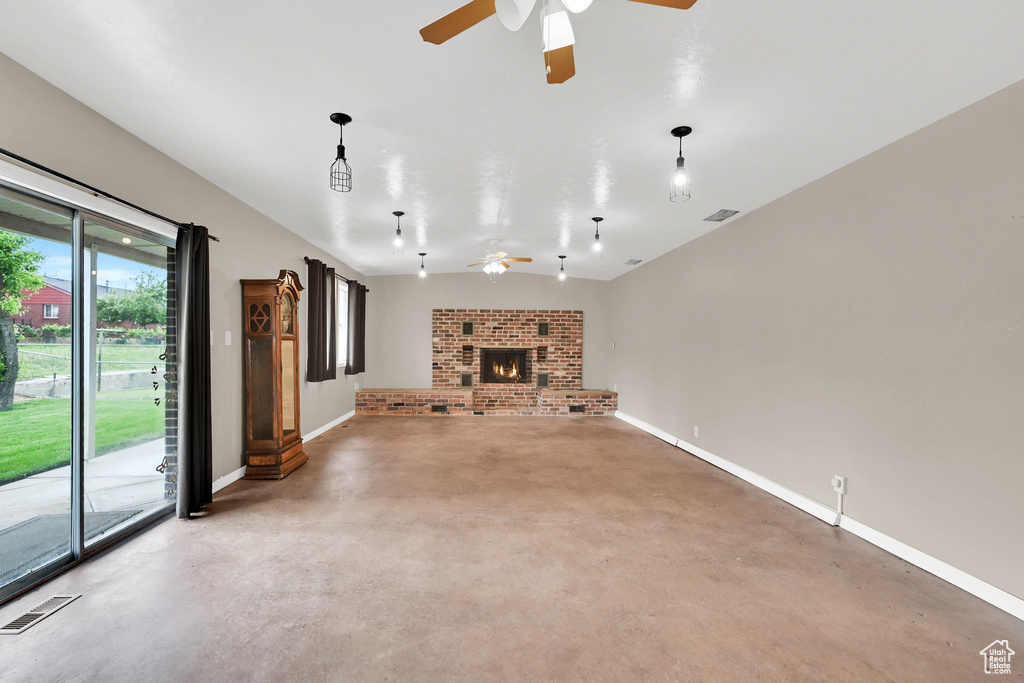 Unfurnished living room with ceiling fan, finished concrete floors, baseboards, and a fireplace