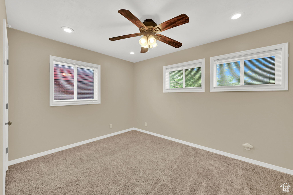 Carpeted spare room featuring a ceiling fan, baseboards, and recessed lighting
