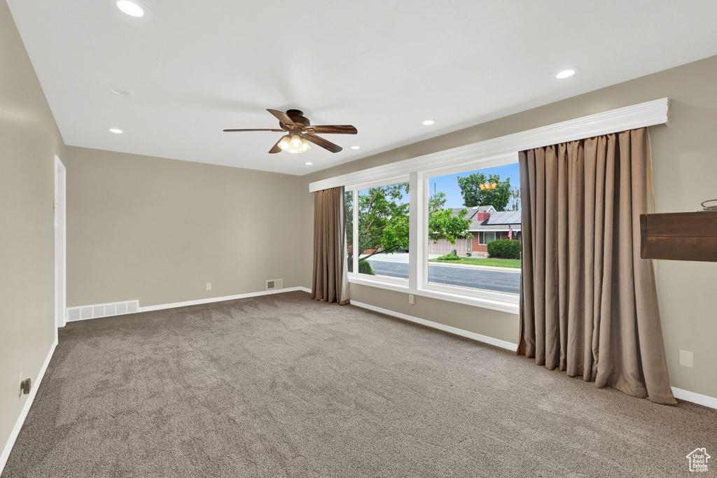 Carpeted empty room featuring ceiling fan, recessed lighting, and baseboards