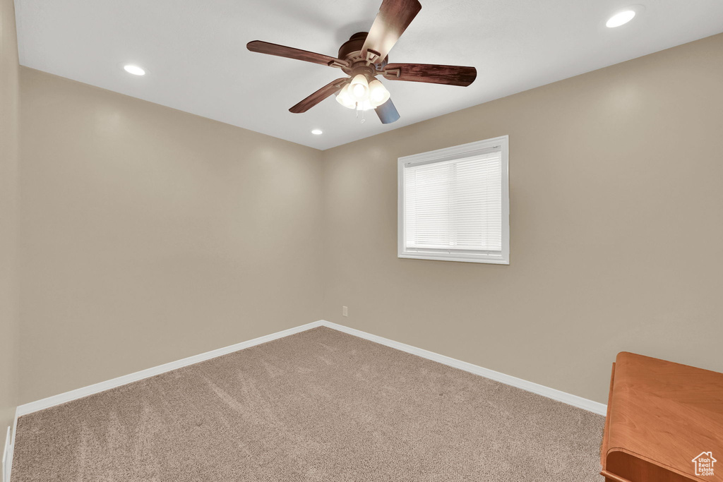 Carpeted spare room with a ceiling fan, baseboards, and recessed lighting