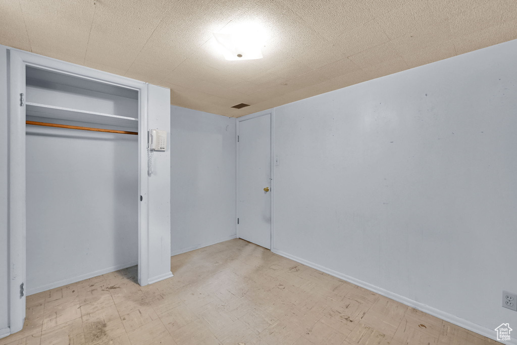 Unfurnished bedroom featuring a closet, baseboards, and tile patterned floors