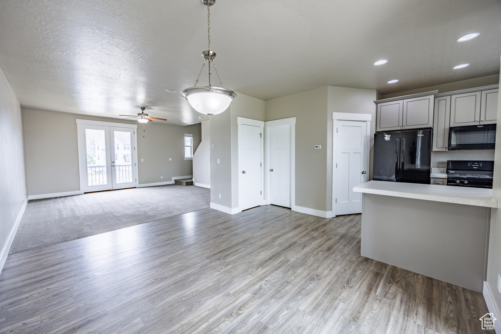 Kitchen featuring black appliances, gray cabinets, baseboards, light countertops, and recessed lighting