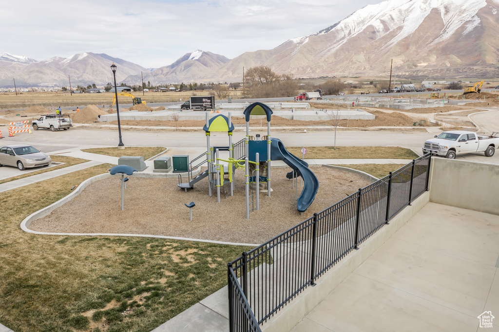 Community play area with a mountain view and fence