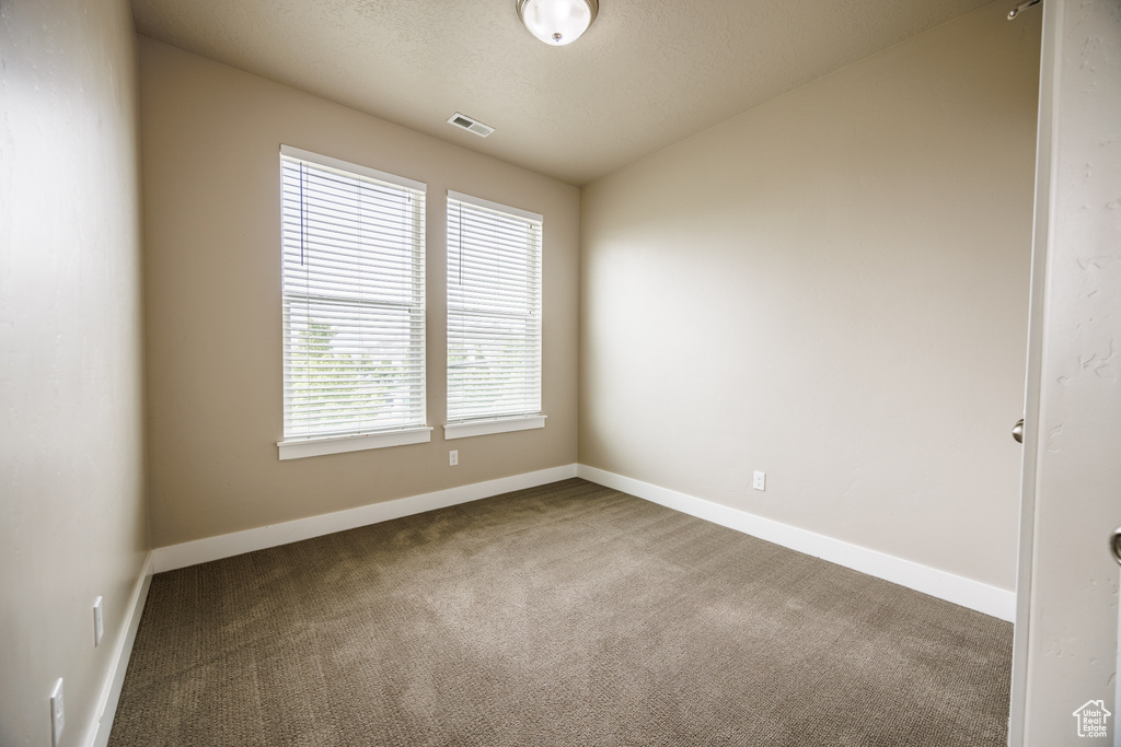 Carpeted empty room featuring baseboards