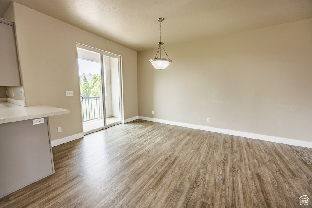 Unfurnished dining area featuring wood finished floors and baseboards